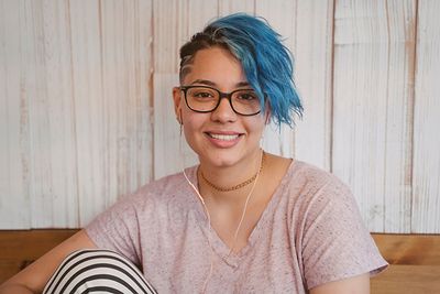 Girl with headphones smiling at camera.