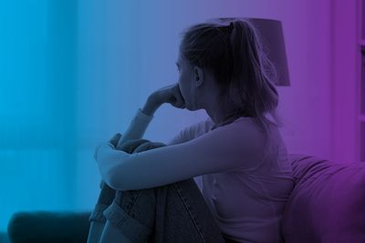 Girl sitting on couch, looking out the window.