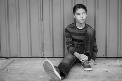 A young boy sitting on the street.